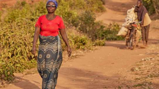 Woman walks in dirt road