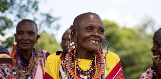 Local woman sits in traditional dress in her Maasai village, Narok County Kenya