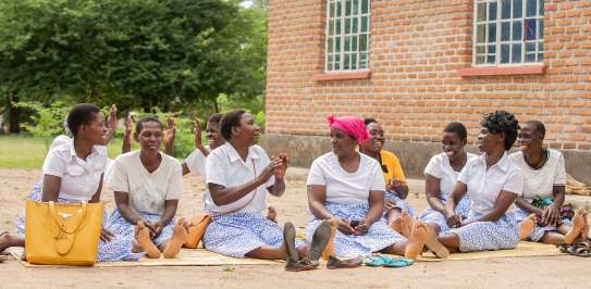 Members of Makande Women's Group sitting outside their processing unit where they make baobab juice in Ngabu Traditional Authority, Chikwawa District, Southern Malawi,