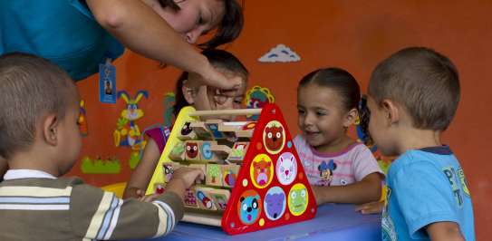 Woman and children play with educational toy
