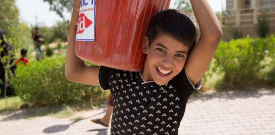 A boy carries a Christian Aid bucket in Iraq