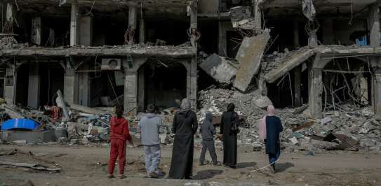 A family looks at an apartment block destroyed by a missile strike. Jalaa Street, Gaza City, 21 February 2024.