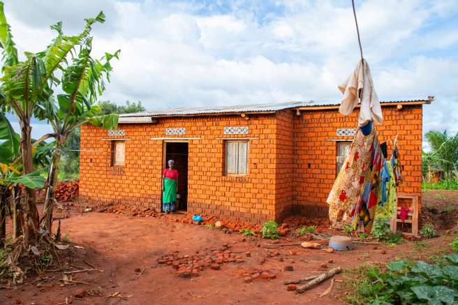 Woman stands at door of her home in Burundi