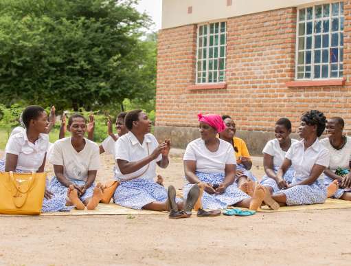 Members of Makande Women's Group sitting outside their processing unit where they make baobab juice in Ngabu Traditional Authority, Chikwawa District, Southern Malawi,