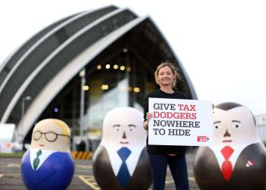 Tax campaigner standing next to some large russian dolls