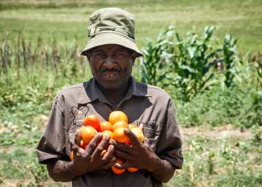A man holding some fresh oranges