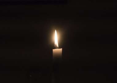 candle light shining in darkness