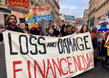 People on a march with a banner reading 'loss and damage, finance now!'