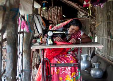 Ponchi Rani Mondol sits at her sewing machine at home in Bangladesh