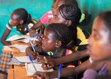 A group of children writing notes at school in Ethiopia