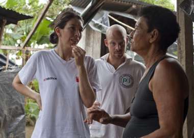 Christian Aid staff member in Act Alliance t-shirt talks to community member in Colombia