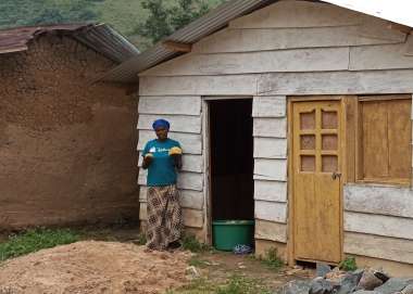Woman stands outside her home in Eastern Congo